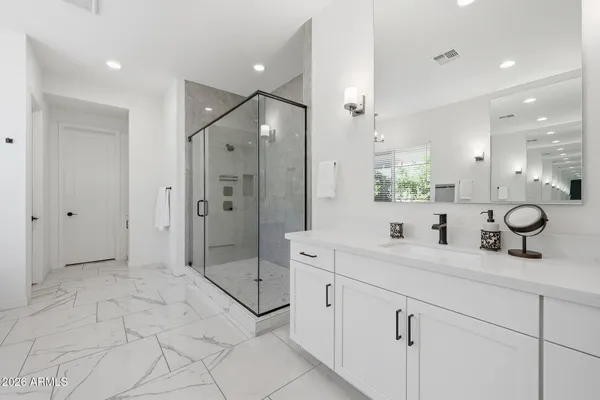 a spacious bathroom with a shower sink and mirror