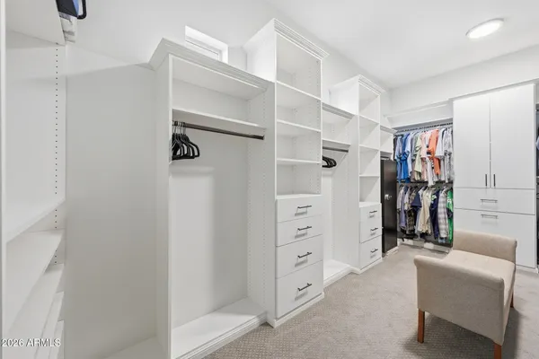 a view of walk in closet with clothes