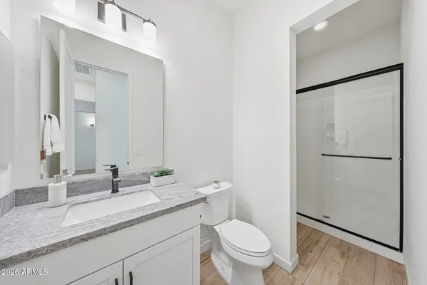 a bathroom with a granite countertop sink mirror vanity and toilet