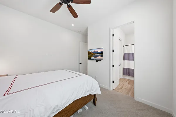 a bedroom with a bed and a refrigerator