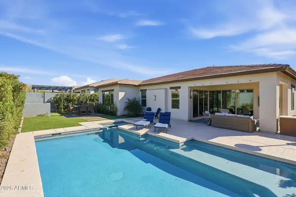 a view of a house with swimming pool and sitting area