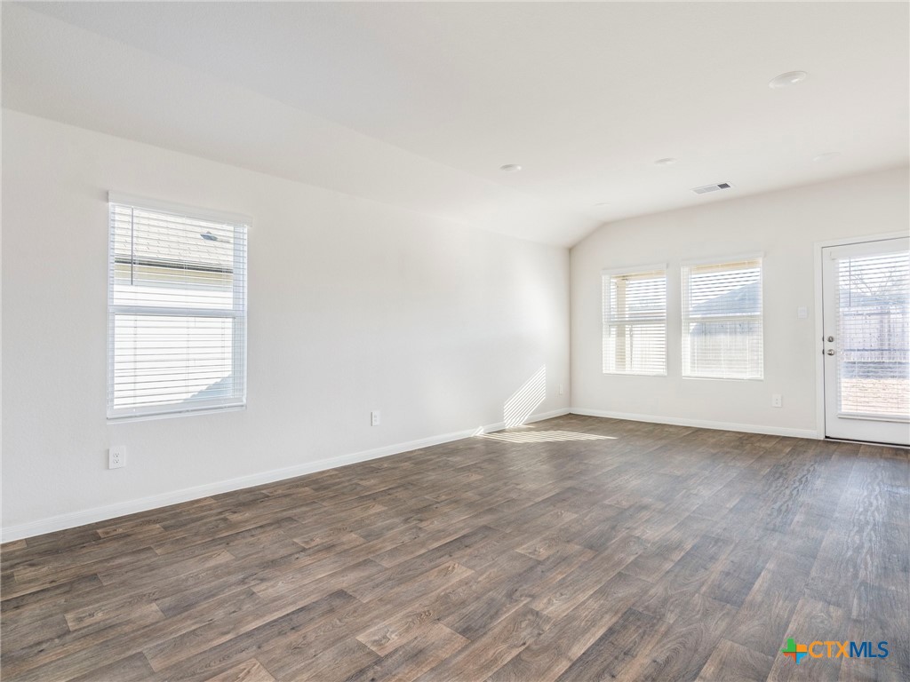 316 Addison Place Lockhart, TX 78644 - Photo 8 of 28 an empty room with wooden floor and windows
