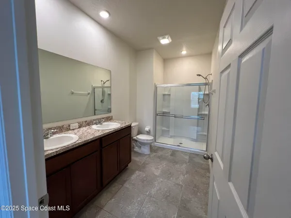 a bathroom with a granite countertop sink mirror and shower