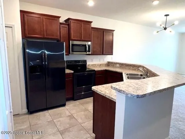 a kitchen with stainless steel appliances granite countertop a refrigerator and a sink