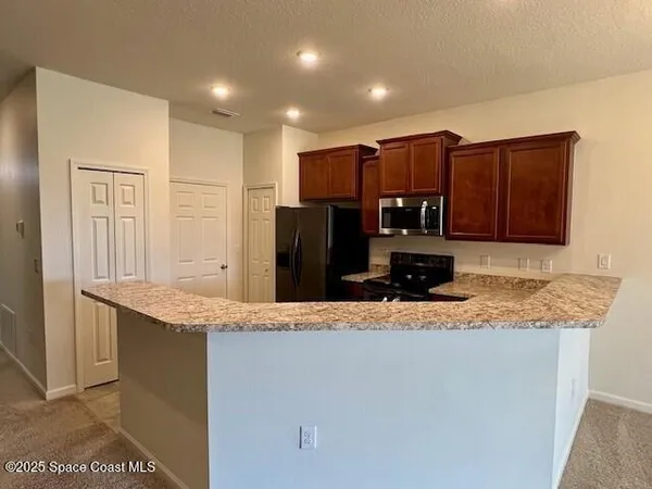 a kitchen with stainless steel appliances granite countertop a refrigerator and a sink