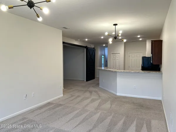 an empty room with a projector and a chandelier fan