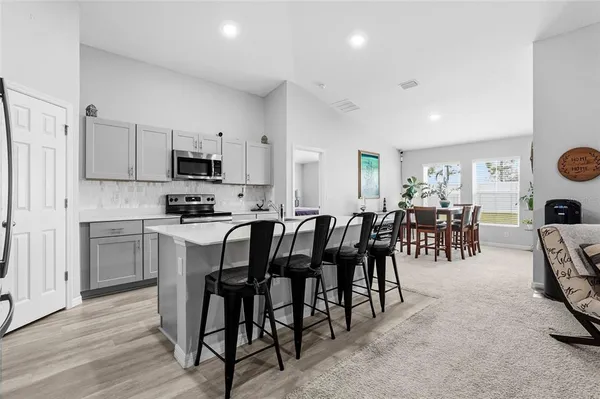 a kitchen with appliances a sink a counter top space and a center island