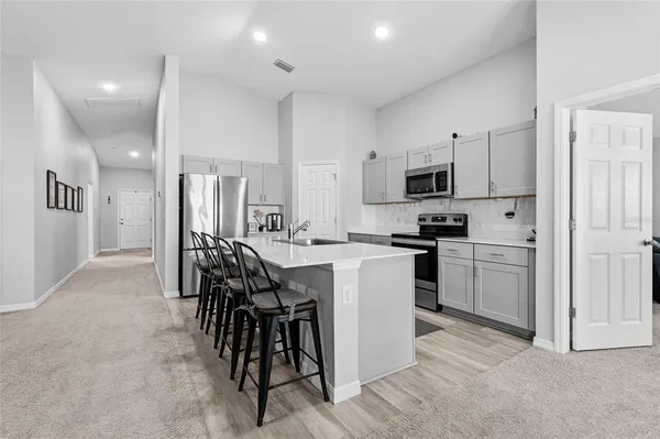 a kitchen with white cabinets and stainless steel appliances