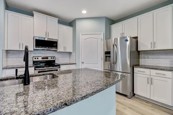 a kitchen with a refrigerator and a stove top oven