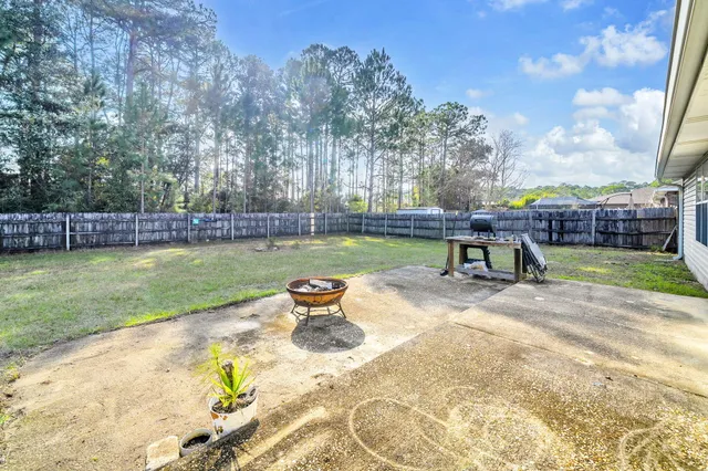 a view of a swimming pool with a patio and a yard