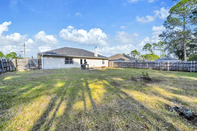 a view of an house with backyard and swimming pool
