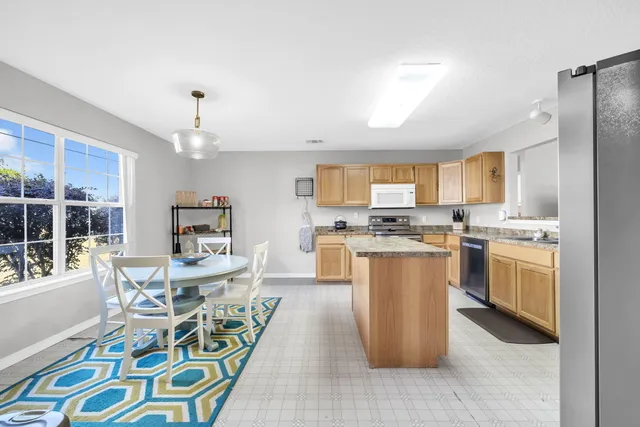 a living room with stainless steel appliances kitchen island granite countertop furniture and a kitchen view