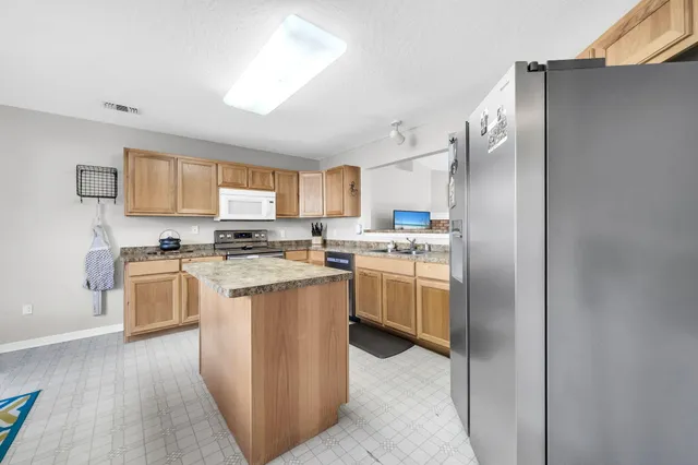 a kitchen with cabinets and a refrigerator