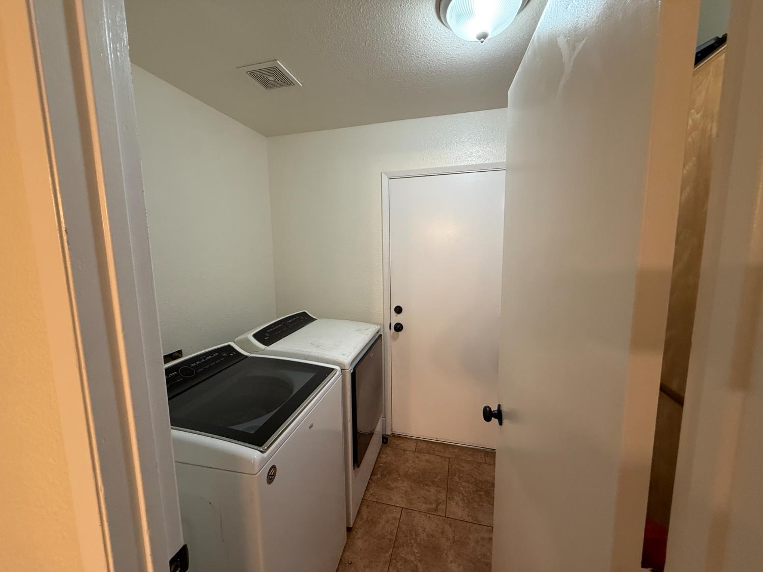 1625 Blue Spruce Way Newman, CA 95360 - Photo 14 of 22 laundry room with washing machine and clothes dryer and a textured ceiling