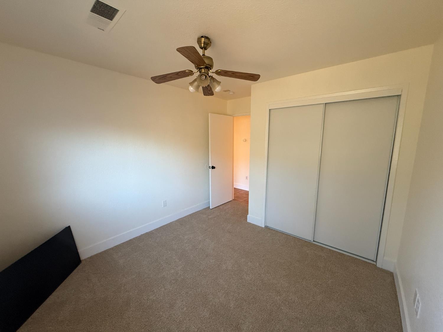 1625 Blue Spruce Way Newman, CA 95360 - Photo 15 of 22 unfurnished bedroom featuring carpet floors, a ceiling fan, and a closet
