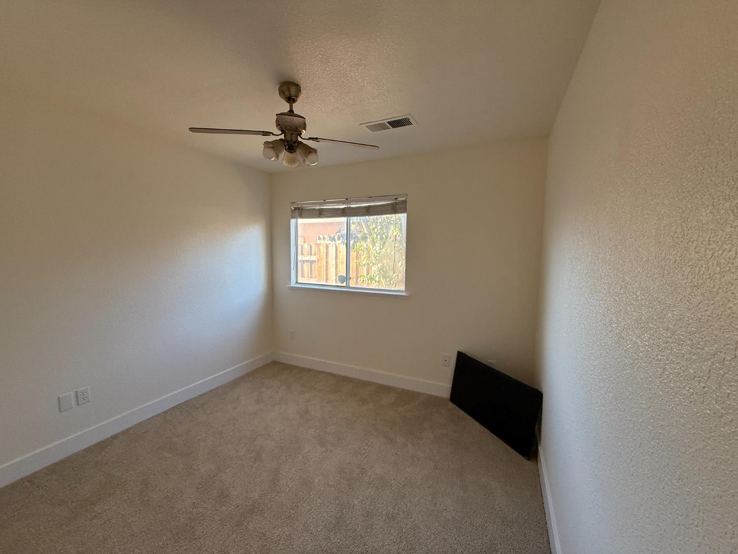 1625 Blue Spruce Way Newman, CA 95360 - Photo 16 of 22 spare room with a textured ceiling, light colored carpet, and ceiling fan