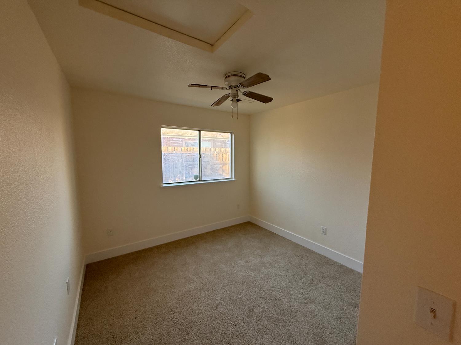 1625 Blue Spruce Way Newman, CA 95360 - Photo 18 of 22 empty room featuring light carpet and a ceiling fan