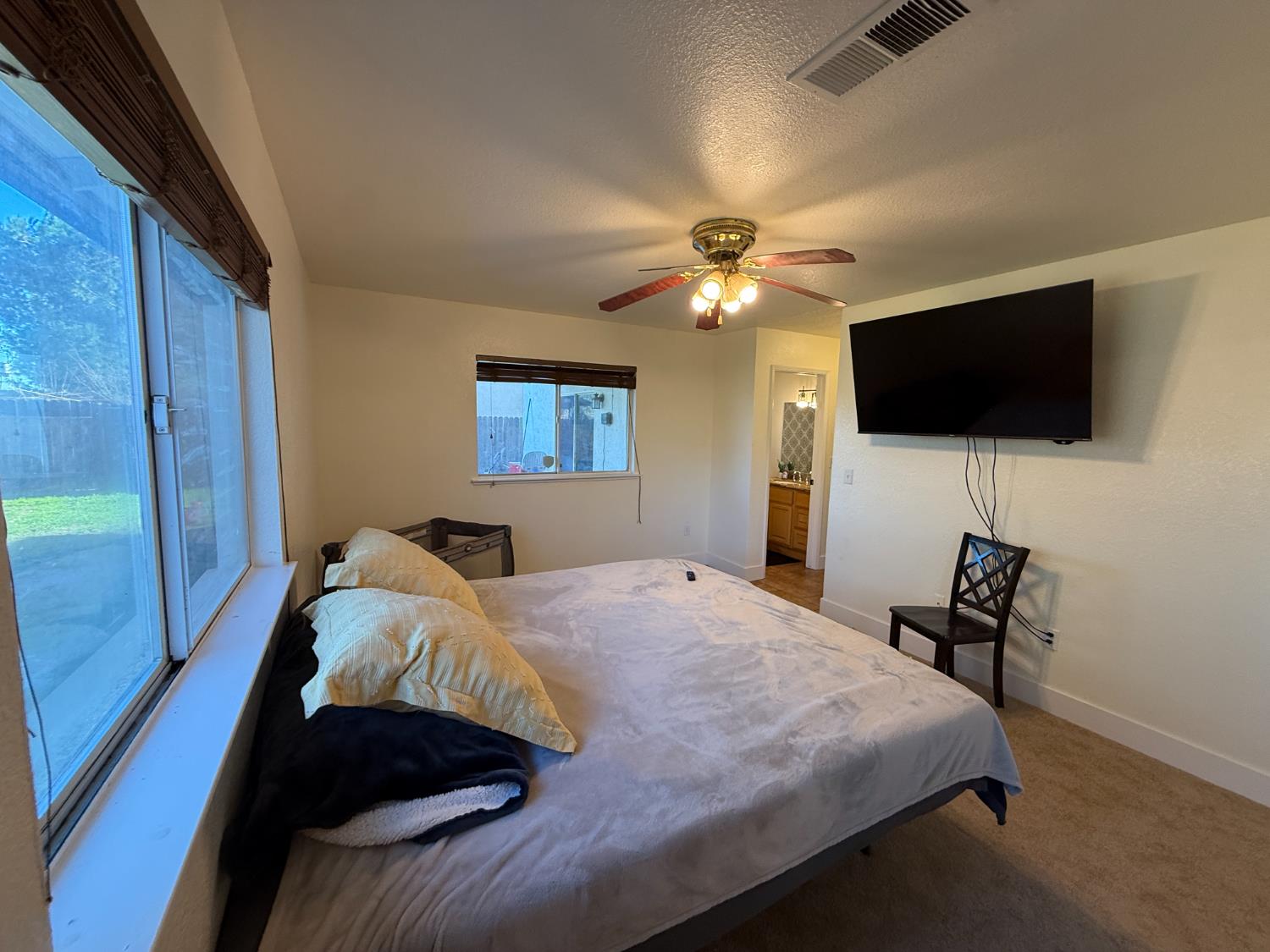 1625 Blue Spruce Way Newman, CA 95360 - Photo 19 of 22 carpeted bedroom with access to exterior, a textured ceiling, ensuite bath, and ceiling fan