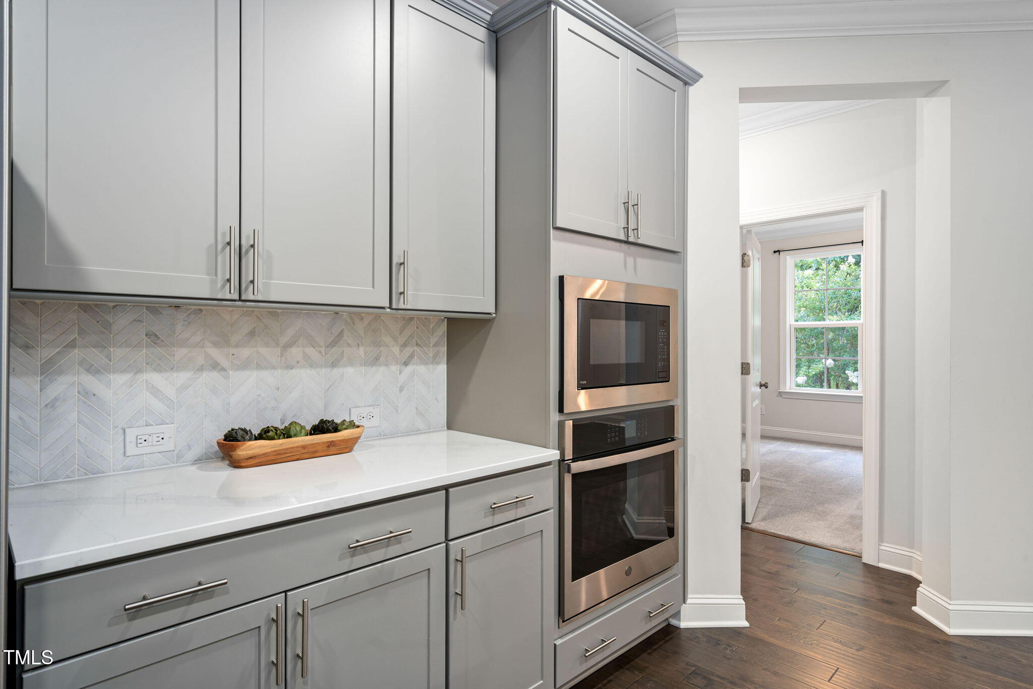 705 Blue Pointe Path Apex, NC 27523 - Photo 11 of 39 a kitchen with stainless steel appliances white cabinets and a wooden floor
