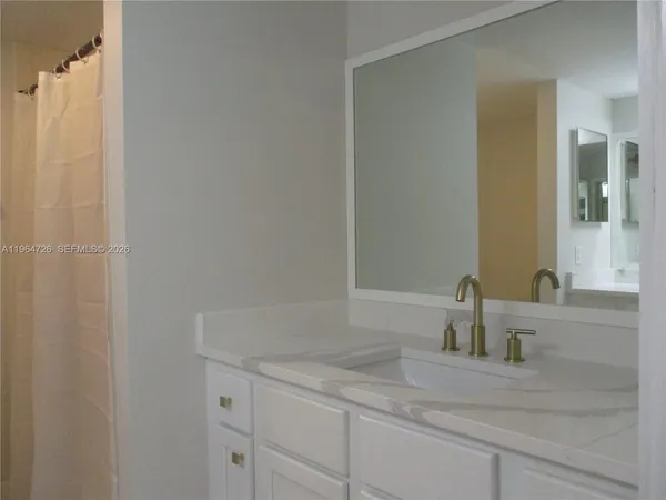 a bathroom with a granite countertop sink and vanity