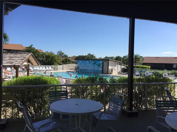 a view of a chairs and table in patio with a lake view