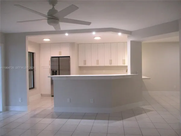 a large kitchen with stainless steel appliances a refrigerator and a counter top space