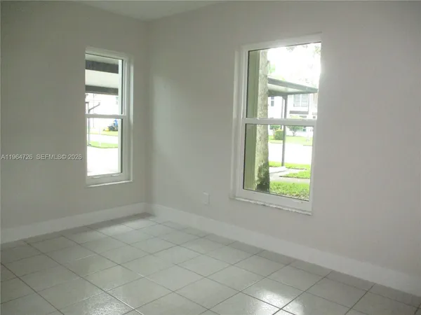 an empty room with a window and a mirror