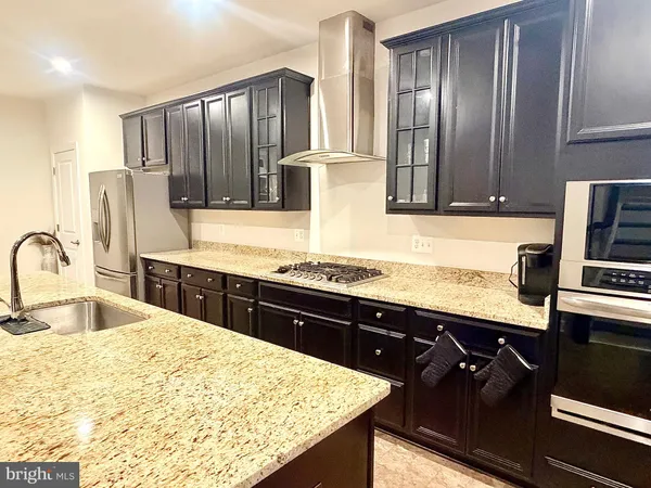 a kitchen with stainless steel appliances granite countertop a sink refrigerator and stove