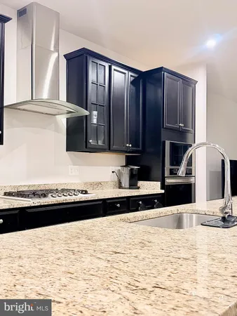 a view of a kitchen with stainless steel appliances wooden cabinets and a counter top space