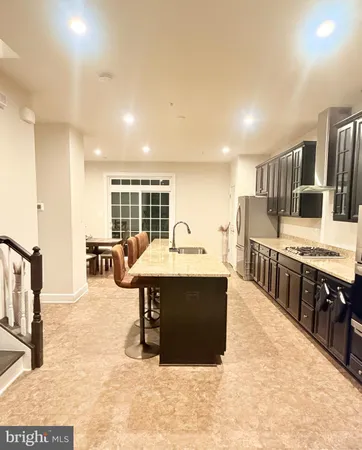 a view of kitchen with stainless steel appliances kitchen island a sink and wooden cabinets
