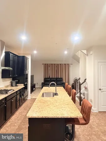 a large kitchen with kitchen island a sink table and chairs
