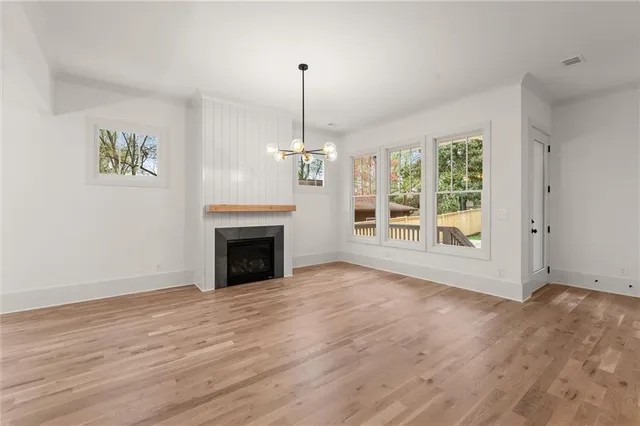 a view of empty room with window and wooden floor