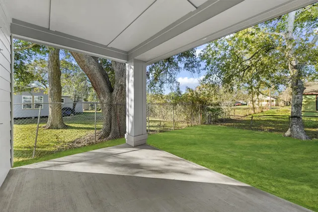 a view of backyard with large trees and plants