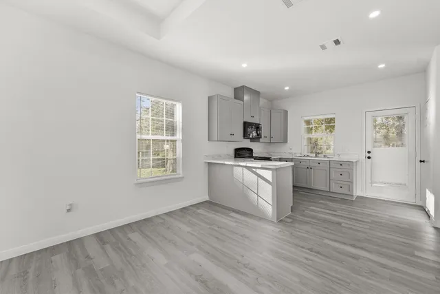 a kitchen with cabinets and wooden floor