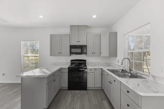 a kitchen with a sink stove top oven and cabinets