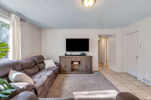 1727 South Sandhill Road Orem, UT 84058 - Photo 6 of 27 Open concept living area featuring a large window with natural light, light gray wall paint, and a built-in entertainment console