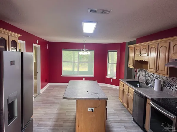 a kitchen with stainless steel appliances granite countertop a stove a refrigerator and a sink