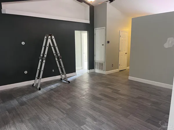 a view of a room with wooden floor and windows