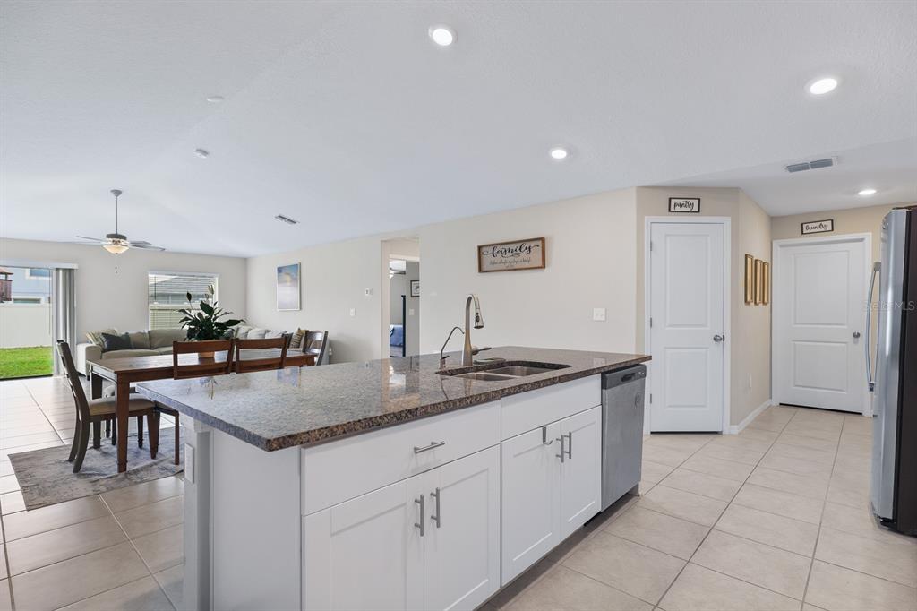 16640 Carlton Pond Street Wimauma, FL 33598 - Photo 12 of 32 a kitchen with center island table and chairs