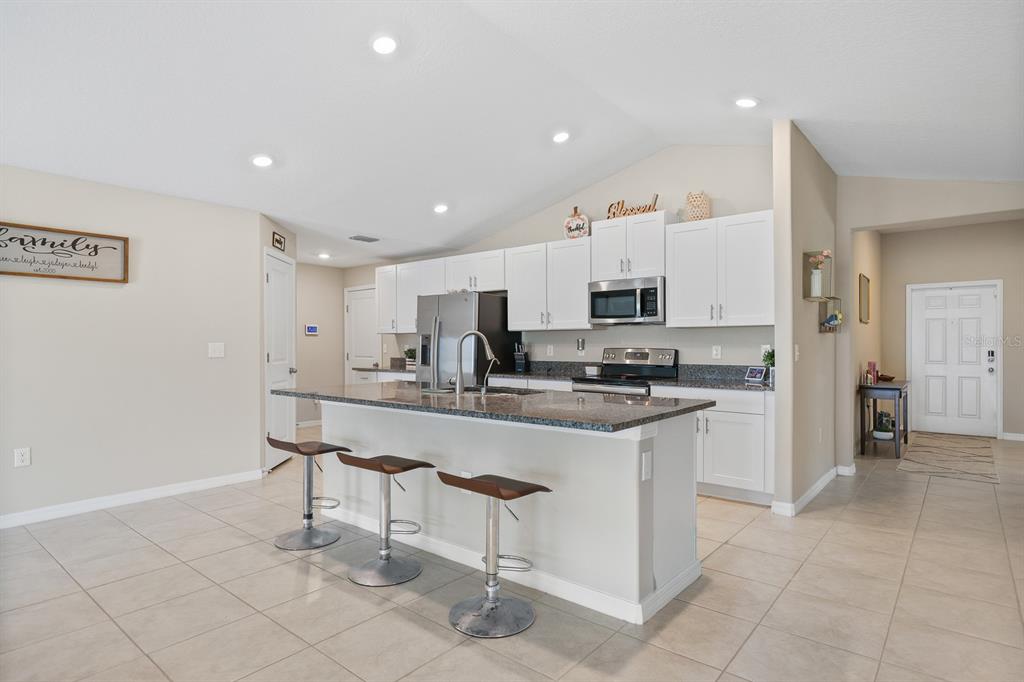 16640 Carlton Pond Street Wimauma, FL 33598 - Photo 8 of 32 a kitchen with stainless steel appliances granite countertop a sink and cabinets