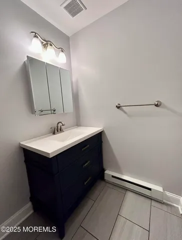 a bathroom with a sink vanity and mirror
