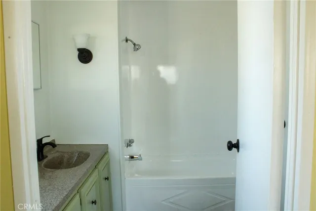 a bathroom with a granite countertop sink and shower