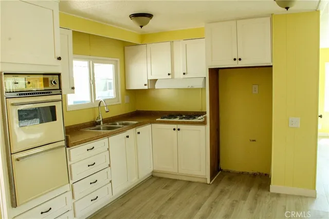 a kitchen with granite countertop cabinets and wooden floor