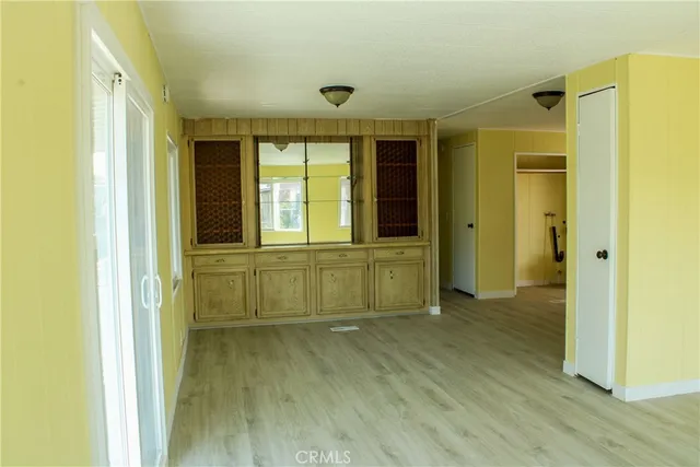 a view of empty room with wooden floor and cabinet