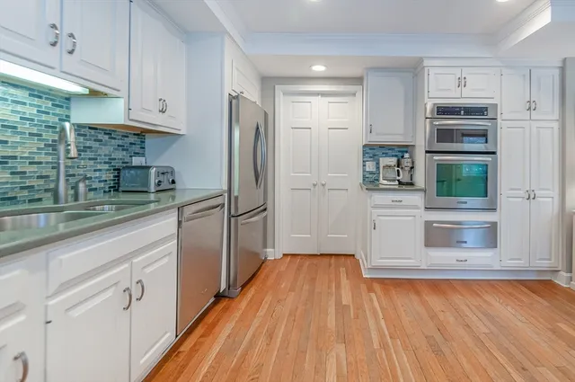 a kitchen with stainless steel appliances a refrigerator and a stove top oven