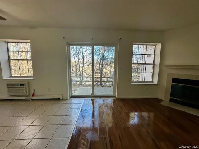 a view of an empty room with glass door and wooden floor