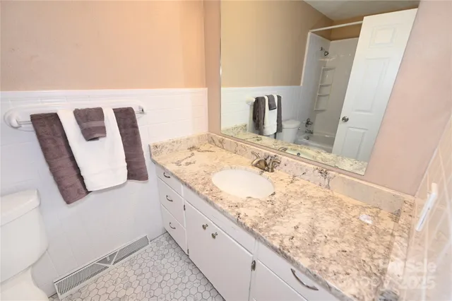 a bathroom with a granite countertop sink and a mirror