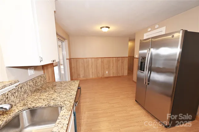 a kitchen with granite countertop a refrigerator and a sink