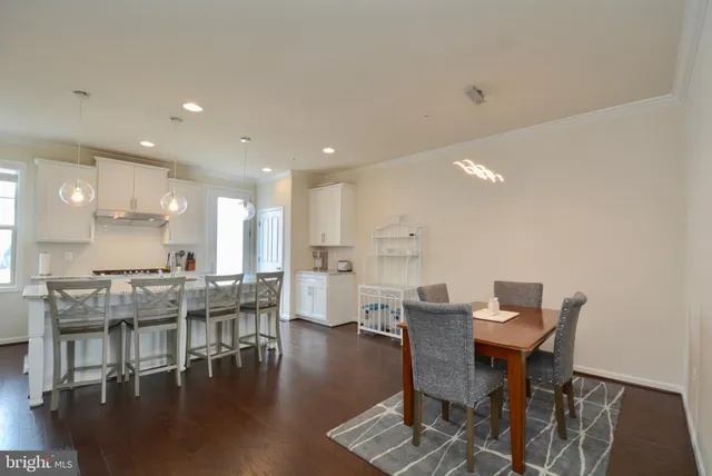 a view of a dining room with furniture wooden floor and a kitchen