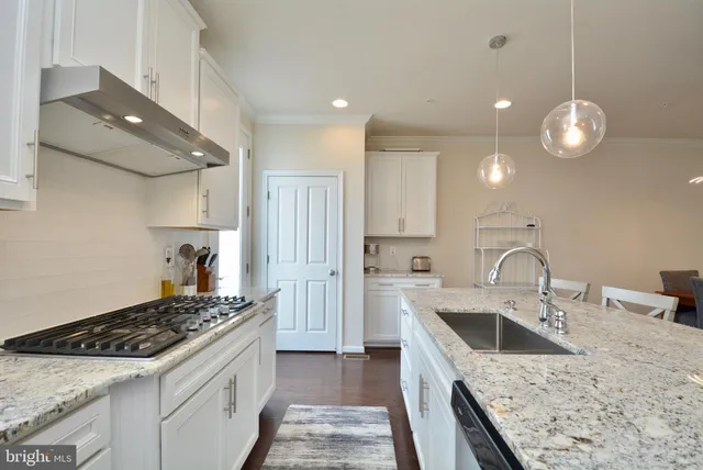 a kitchen with a stove sink and cabinets
